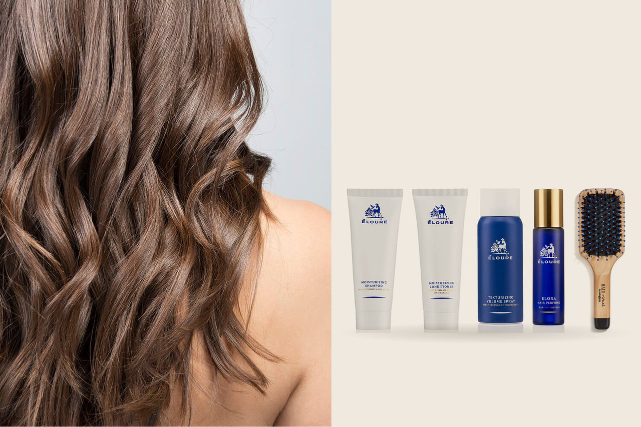 Left, soft brown waves seen from behind; right, Maison Éloure travel-size bottles, a hair perfume and a Sisley pocket brush on a warm stone ground.